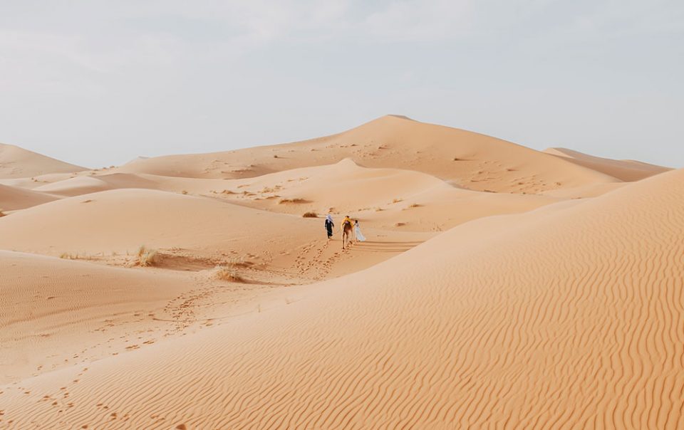 Sahara desert in Erg Chebbi Based in Morocco with two people walking in the landscape