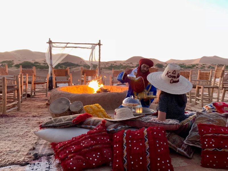 Chica en desierto de marruecos bebiendo un tipoco te de Merzouga en Kam Kam Dunes